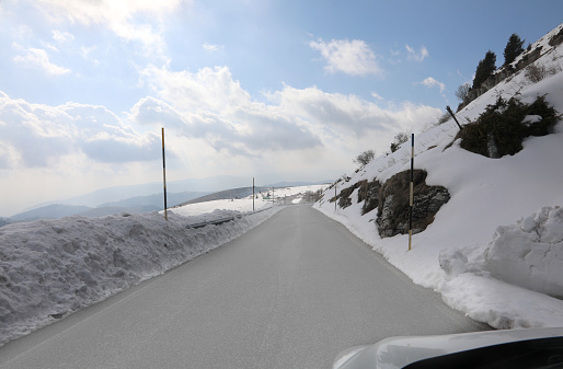 dangerous slippery mountain road with ice sheet after snowfall in winter