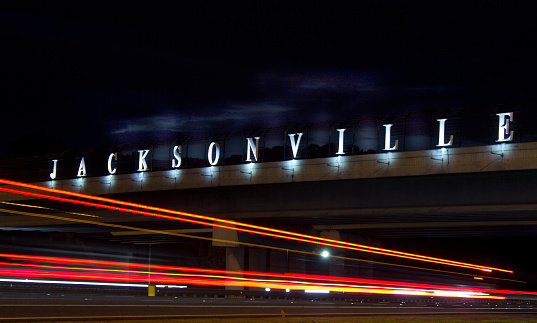Sign entering Jacksonville, Florida with streaking highway lights ￼￼