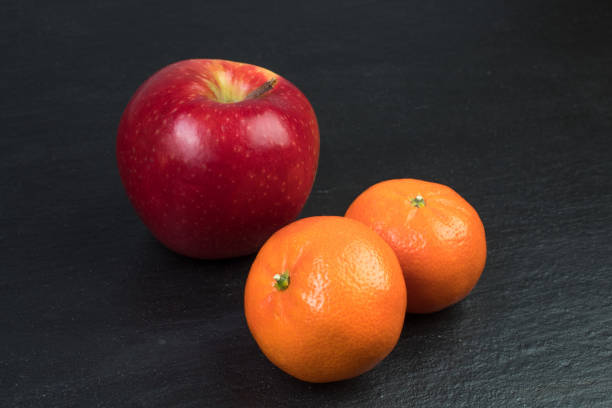 Fruits. Apples, oranges tangerines on a black background