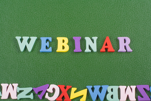 WEBINAR word on green background composed from colorful abc alphabet block wooden letters, copy space for ad text. Learning english concept