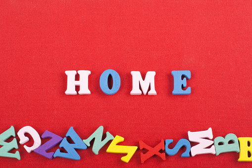 HOME word on red background composed from colorful abc alphabet block wooden letters, copy space for ad text. Learning english concept