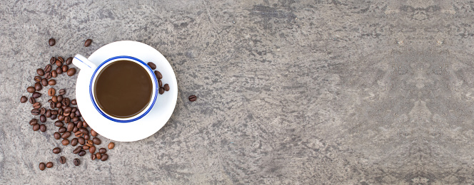 Cup of coffee, coffee beans on a concrete background. top view