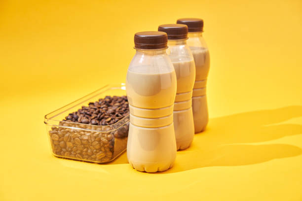 Various Coffee Latte in Recycled PET Plastic Bottles and fresh Coffee Beans on Yellow Background