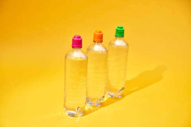 Water in Recycled PET Plastic Bottles on Yellow Background
