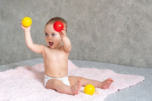 A child is trying to show someone the colored balls he is playing with.