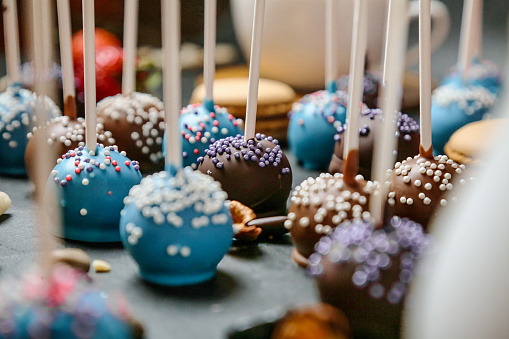 A variety of cake pops neatly organized on a tabletop.