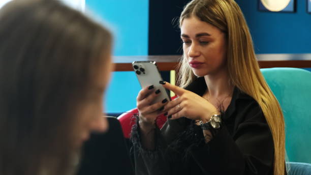 istock Blonde employee works on phone typing information at work 2088836633