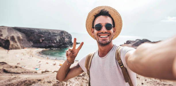 istock Handsome young man taking selfie with smart mobile phone at the beach - Smiling guy looking at camera outside - Summer vacation and technology concept 2088871922