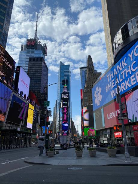 istock Times Square intersection no people, sidewalk in shadow under blue sky. - New York, NY, April 7, 2020 2088872145