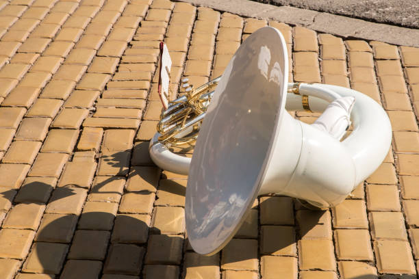 White fiberglass sousaphone on town street ceramic pavers closeup