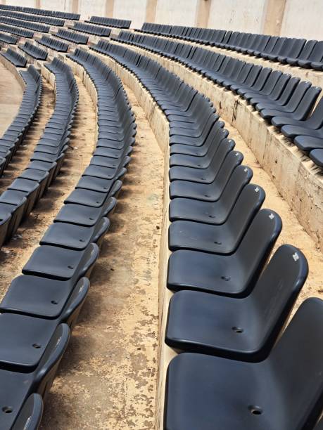 A row of black seats in an empty  stadium