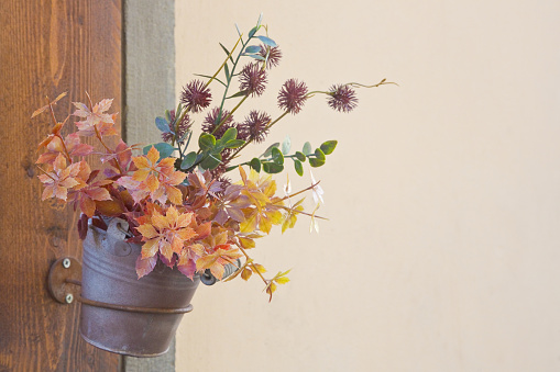 Small ornamental vase of flowers against a wall - image with copyspace - real photo shoot