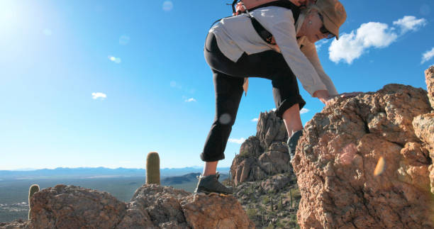 istock Mature woman ascends rock ridge crest 2088927309