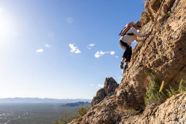 istock Mature woman ascends rock ridge crest 2088928562