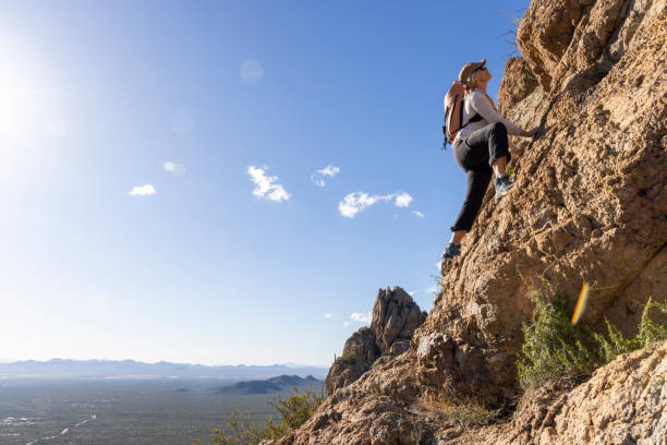 istock Mature woman ascends rock ridge crest 2088929671