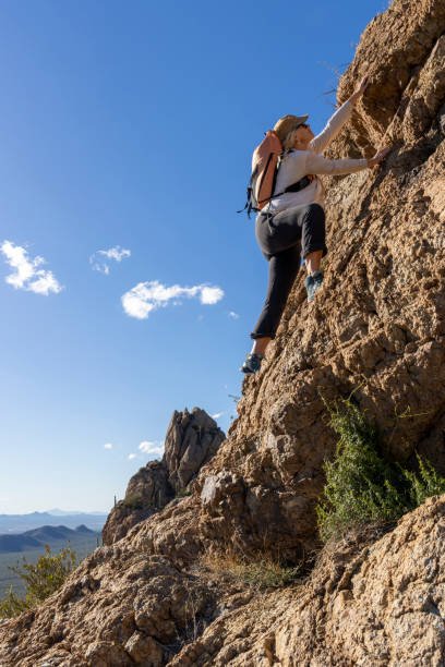 istock Mature woman ascends rock ridge crest 2088929674