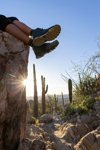 Hikers feet on rock above desert on rock above desert at sunset