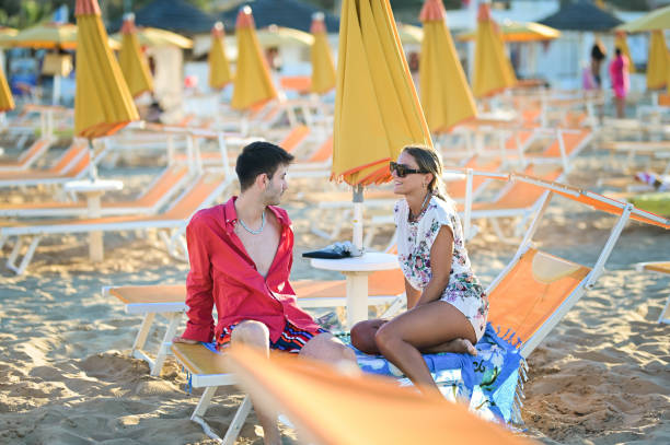 istock Young people relaxing on chaise lounge on a beach. 2088938171