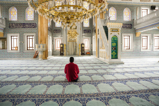 Muslim young man praying in the mosque