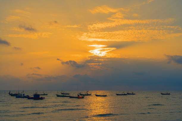 Long-tailed boats in Thailand at sunset.