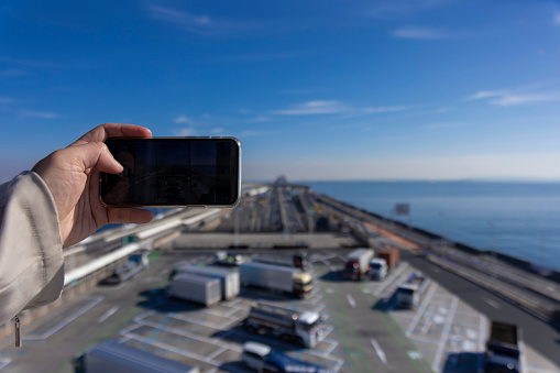 A traffic jam shooting by smartphone on the highway at Tokyo bay area in Chiba. High quality photo. Kisarazu district Chiba Japan 01.30.2024 Here is the highway parking called UMIHOTARU PA in Chiba Japan.