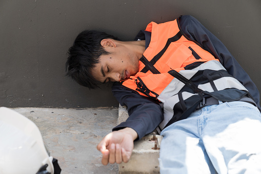 Asian male worker injured, feel sick, have a headache at construction site. Health safe of work and safety first concept