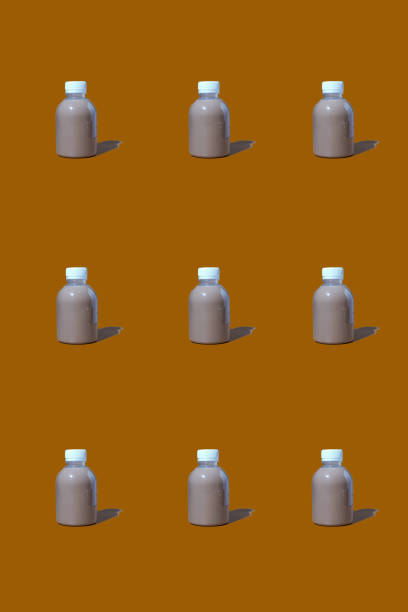 Clear PET bottles put with coffee liquid inside on brow background, seeing red color through bottles.