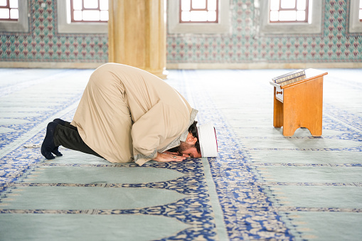 Imam praying in the mosque prostrates