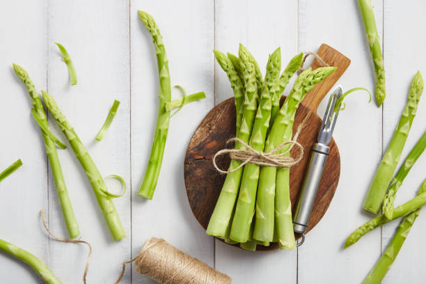 istock Peeling fresh green asparagus on wooden cutting board 2089042021