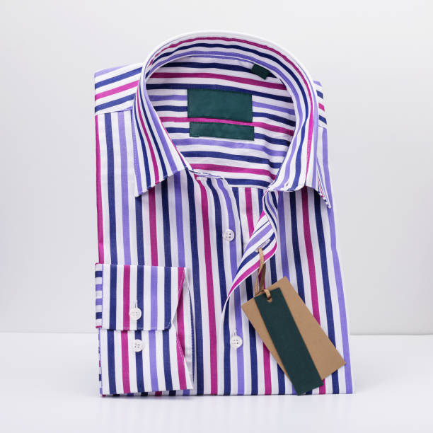 istock Classic folded men's shirt in colored stripes with long sleeves on a light background standing on a stand 2089043256