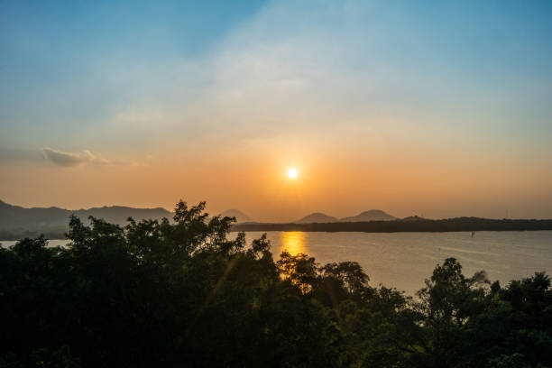 A mesmerizing view of the sunset over a lake, surrounded by mountains at Heritance Kandalama, Dambulla, Sri Lanka.