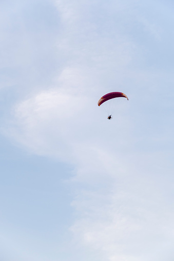 paramotor glider flying in the air deep blue paraglider on blue bright sky