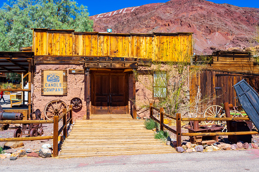 Old western style horse drawn wagons lined up in front of old western buildings,\n\nTaken in Cody, Wyoming.