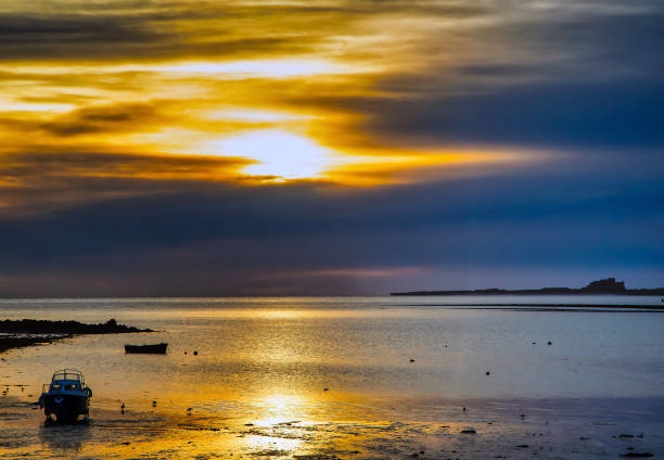 ホーリー島からのバンバラ城の冬の朝の眺め - bamburgh castle northumberland england dawn north sea ストックフォトと画像