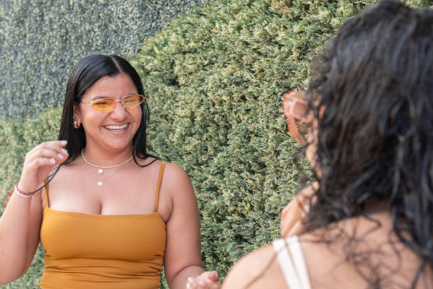 istock Young Woman in yellow top gesturing while talking with friends. 2089169629