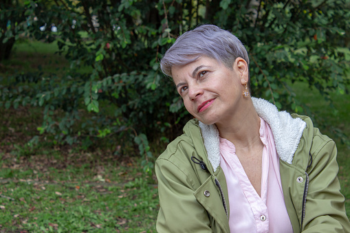Middle aged woman posing in a public park
