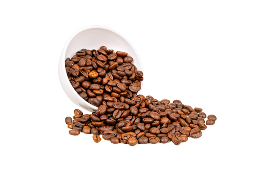 Roasting Arabica coffee beans scattered from a bowl on a white background