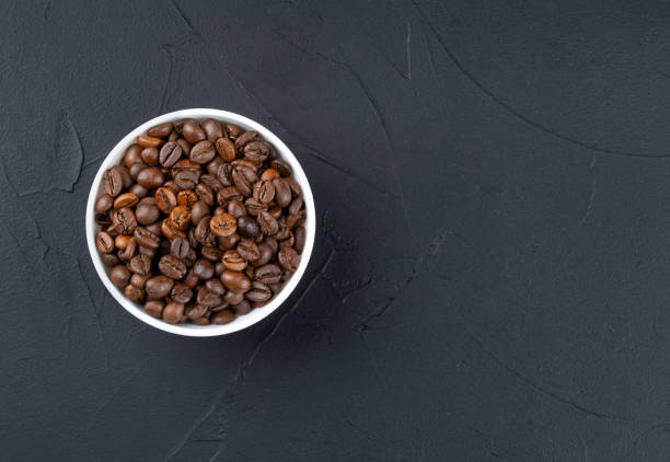 Roasting coffee beans in a bowl on a dark background