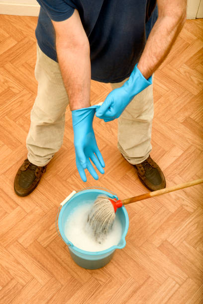 Man wearing rubber gloves before cleaning the floor