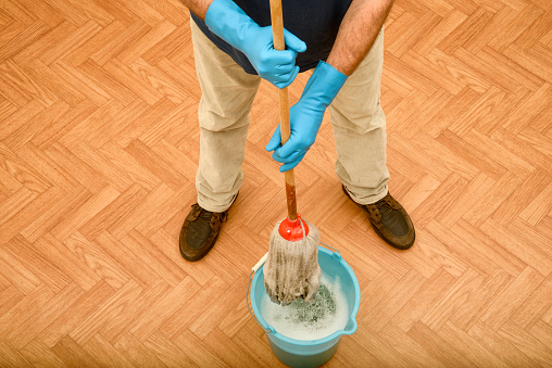 Man wearing rubber gloves before cleaning the floor