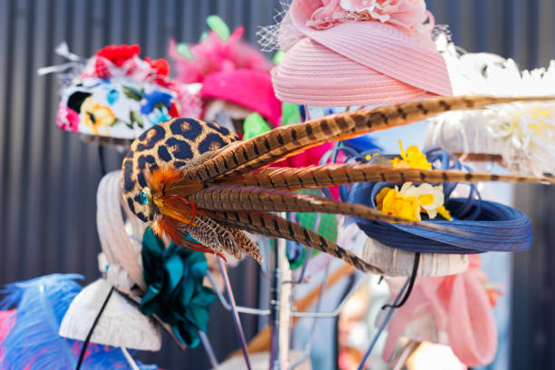 There are many different hats with feathers, flowers at the exhibition.