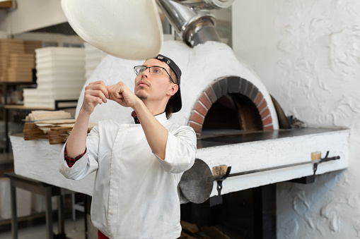 Pizza Chef makes the pizza dough spin in the air to make it thin and soft