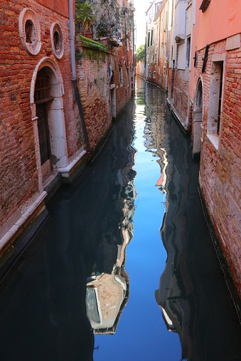 glimpse of the island of Venice in northern Italy with the navigable canal and the reflection of the houses on the water