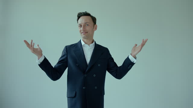 wide shot of happy confident young business man, employer in suit turning around, hands gesture in the air