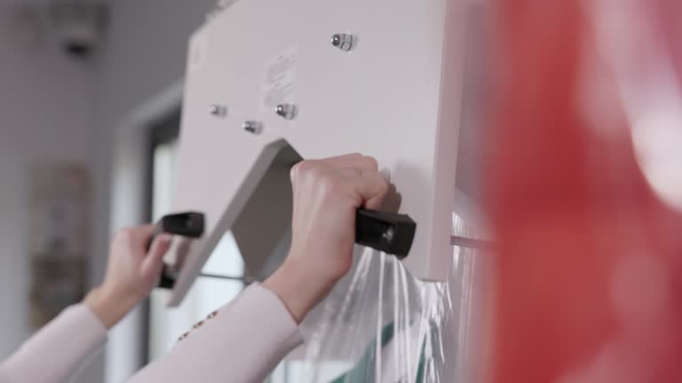 Hands Packing Suit With Laundry Packing Machine At Laundry Shop. closeup, slow motion shot