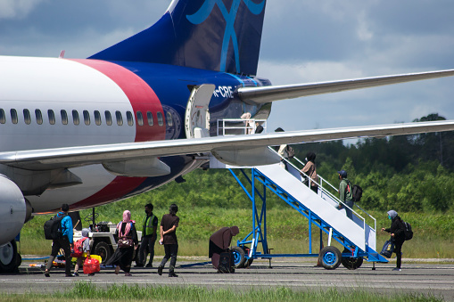 Sorong, Southwest Papua, Indonesia, 06/19/2021. The commercial plane embark the passengers at the taxi yard of Sorong Airport.