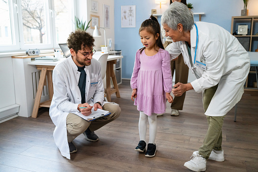 Japanese girl having an annual medical check-up with a male and a female Caucasian pediatricians
