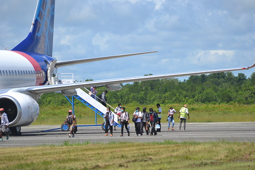 Sorong, Southwest Papua, Indonesia, 06/19/2021. The commercial plane embark the passengers at the taxi yard of Sorong Airport.