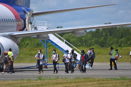 Sorong, Southwest Papua, Indonesia, 06/19/2021. The commercial plane embark the passengers at the taxi yard of Sorong Airport.