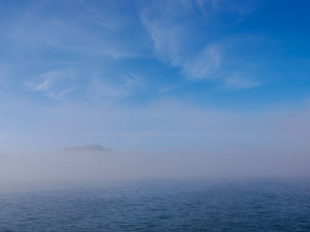In the foreground, Lake Czorsztynskie and fog rising from the water. Beautiful sky with clouds. Czorsztyn. Poland.